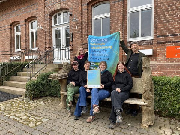 Team Umweltbildung auf Gut Herbigshagen präsentiert Urkunde und Fahne