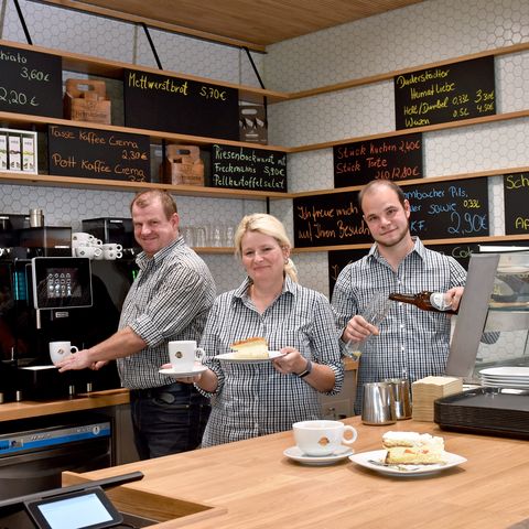 Team Café GUT(e) auszeit hinter dem Tresen präsentiert Produkte