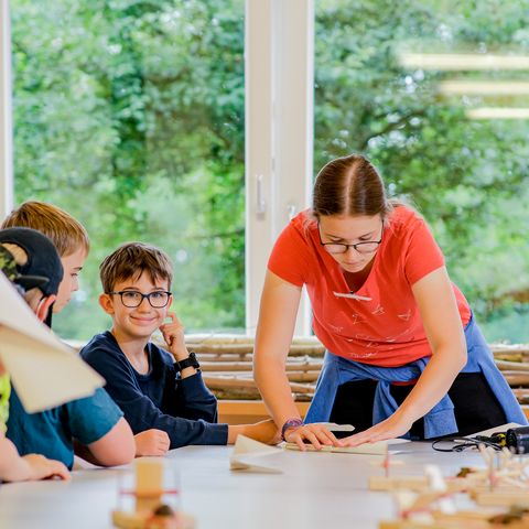 Kinder mit Dozentin am Tisch im Kreativraum Gut Herbigshagen