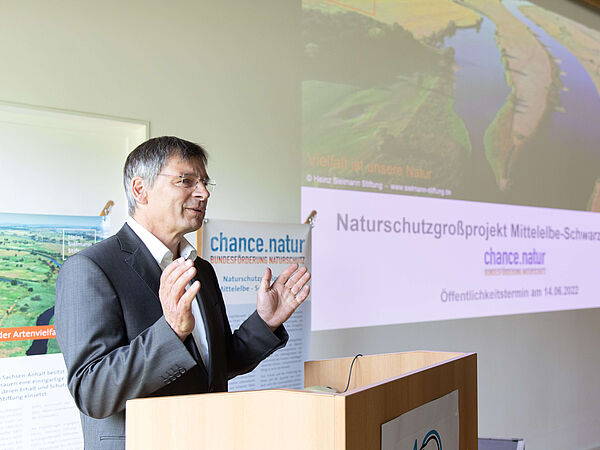 Guido Puhlmann: Leiter des Biosphärenreservats Mittelelbe. Leiter des Biosphärenreservats Mittelelbe Guido Puhlmann am Rednerpult. Rechts ist die Projektion einer PowerPoint-Folie mit Elbefoto.
