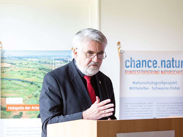 Prof. Dr. Armin Willingmann: Minister für Wissenschaft, Energie, Klimaschutz und Umwelt des Landes Sachsen-Anhalt. Landesumweltminister Prof. Dr. Willingmann am Rednerpult. Hinter ihr befinden sich Banner der Heinz Sielmann Stiftung Stiftung und des Förderprogramms chance.natur.