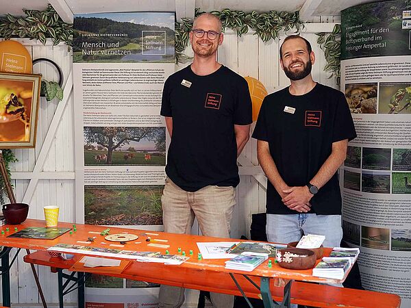 Carl-Christian Wippermann (rechts), Leiter der Biotopverbünde Südbayern und Mitarbeiter Andreas Nemetz am Stand der Heinz Sielmann Stiftung auf dem Tollwood Sommerfestival 2025.