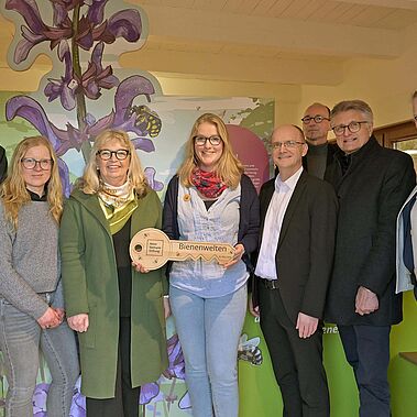 Gruppe von Personen (Vorstand, Stiftungsrat und Förderpartner) übergeben symbolischen Schlüssel an Projektleitung